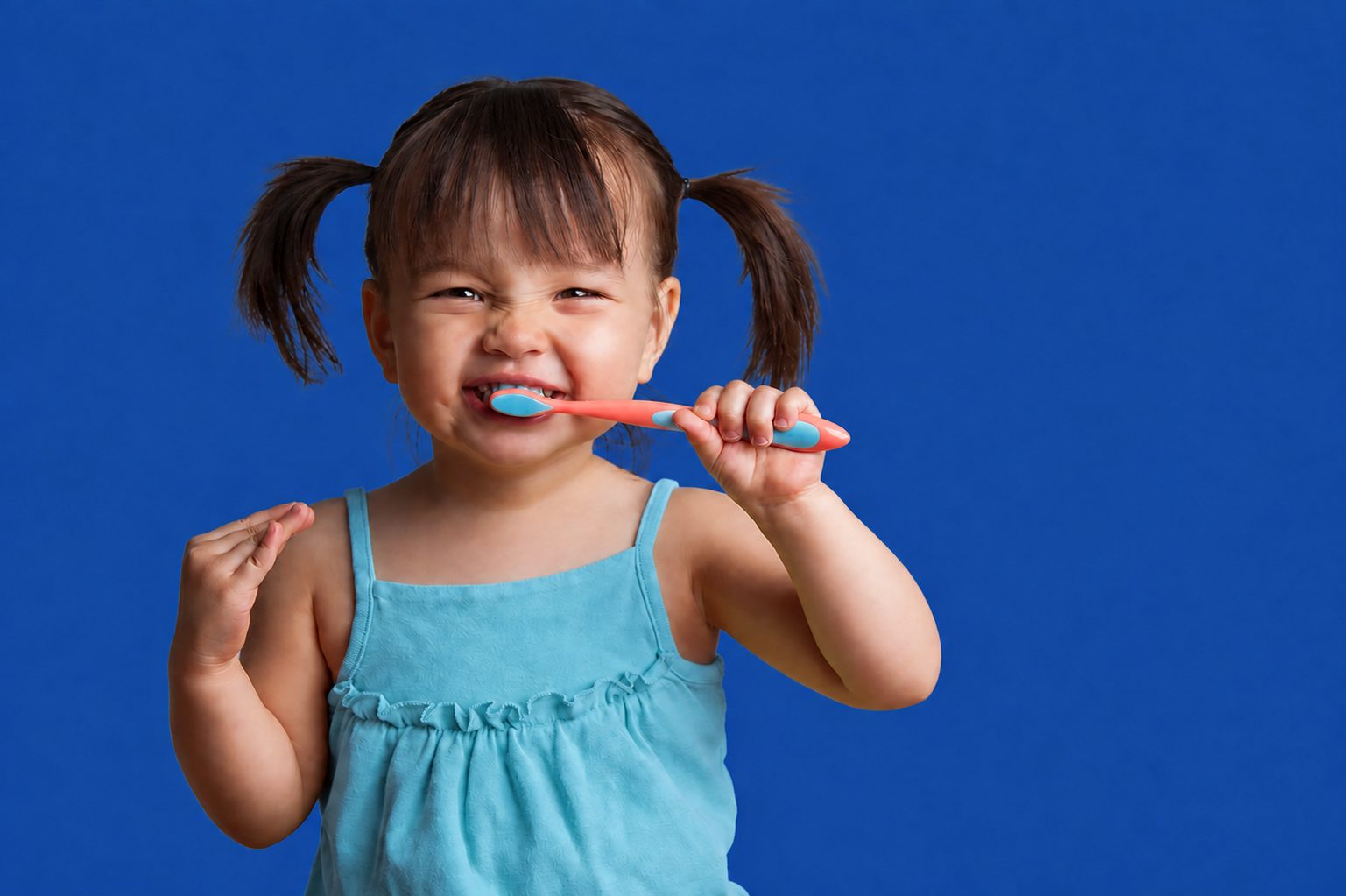 Young child brushing her teeth
